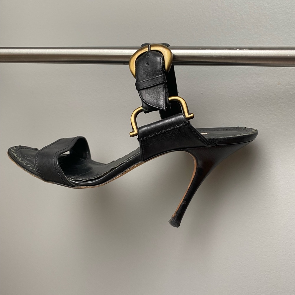 Manolo Blahnik black leather with brass colored hardware.